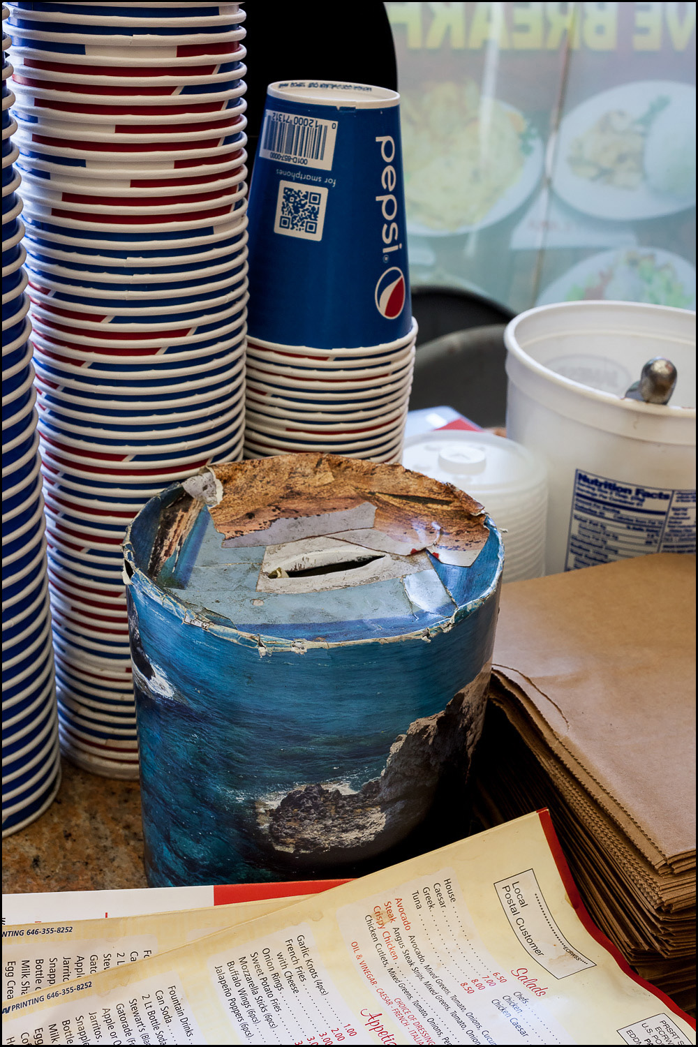 Photo: collage cardboard tube used as a tip jar.